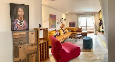 a living room with a couch and a painting on the wall at Top Floor Apartment with terrace and pool in Marrakech