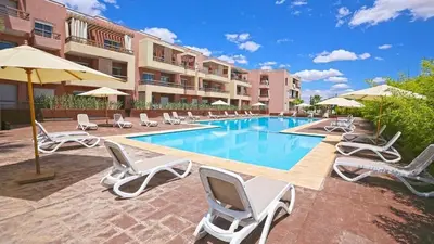 a swimming pool with lounge chairs and a hotel at Top Floor Apartment with terrace and pool in Marrakech