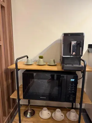 a microwave on a stand with a toaster oven on top at Cosy Studio Cinema PS5 and home cinema 10 min Downtown in Marrakech