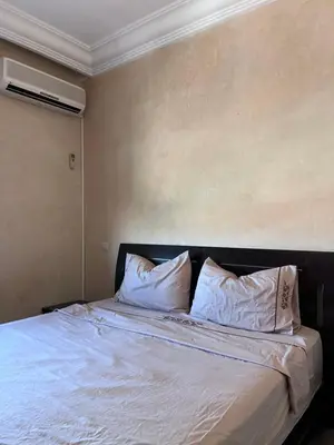 a bedroom with a bed with white sheets and pillows at Darhome in Marrakech