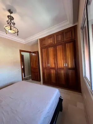 a bedroom with a bed and wooden cabinets at Darhome in Marrakech