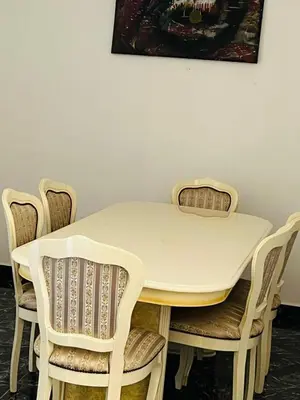 a table and chairs with a white table and a painting at Spacious and comfortable villa in Marrakech