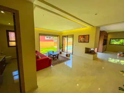 a living room with a red couch and a fireplace at Sublime Villa avec Piscine et Jardin à Marrakech in El Rhechat