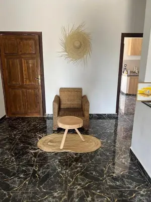 a living room with a chair and a table at Spacious and comfortable villa in Marrakech