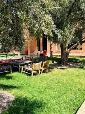 a group of picnic tables and a tree in a park at Spacious and comfortable villa in Marrakech