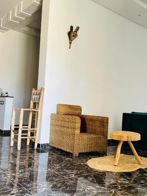 a living room with a chair and a table at Spacious and comfortable villa in Marrakech