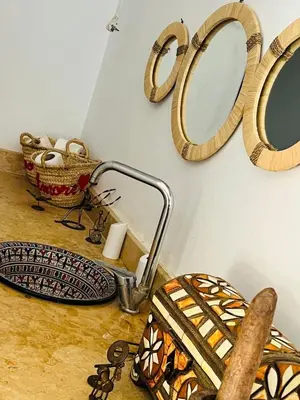 a bathroom with a sink and mirrors on the wall at Spacious and comfortable villa in Marrakech
