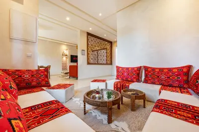 a living room with red and white couches and a table at Villa Cõrdõba piscine chauffée et sans vis-à-vis in Marrakech