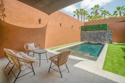 a patio with a pool and chairs and a table at Villa Cõrdõba piscine chauffée et sans vis-à-vis in Marrakech