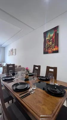 a dining room table with chairs and a painting on the wall at Refined stay with 4 pools in Marrakech in Marrakech