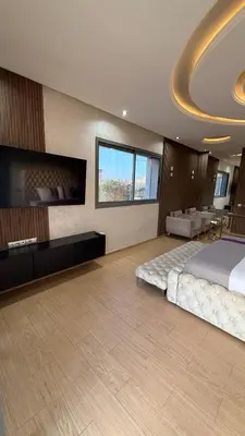 a large bedroom with a large bed and a flat screen tv at Villa Targa Marrakech in Marrakech
