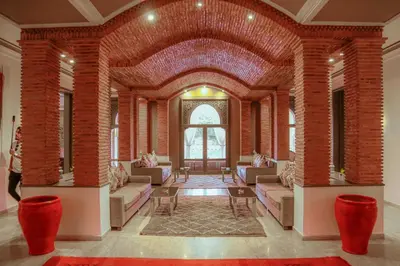 a large room with brick walls and couches and a table at Palais Soufi 8 chambres in Marrakech