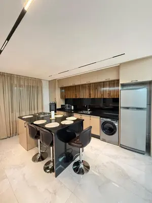 a large kitchen with a black island in a room at Marrakech guliz location vacances in Marrakech