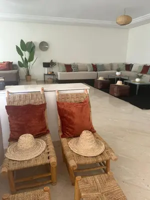two chairs with pillows sitting in a living room at Residence La Perle de Atlas Appartement in Marrakech