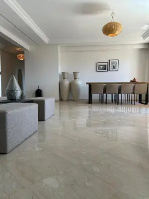 a living room with a table and vases at Residence La Perle de Atlas Appartement in Marrakech