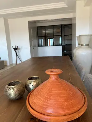 a wooden table with three vases on top of it at Residence La Perle de Atlas Appartement in Marrakech