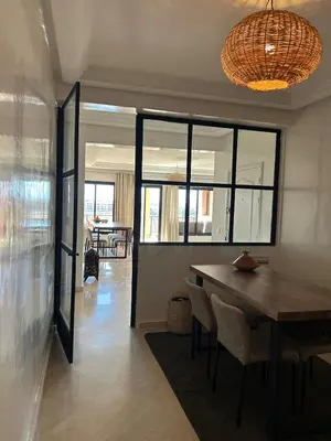 a dining room with a table and some chairs at Residence La Perle de Atlas Appartement in Marrakech
