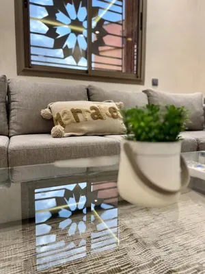 a living room with a couch and a glass table at Yumo - Cozy 3 in Marrakech