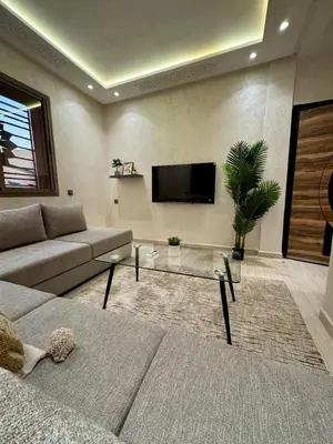 a living room with a couch and a tv at Yumo - Cozy 3 in Marrakech