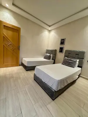 a bedroom with two beds and a wooden door at Yumo - Cozy 3 in Marrakech