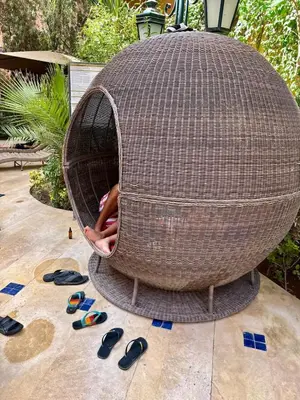a wicker chair with a person inside of it at Elegant 2BR, Pool & Gym Access in Marrakech