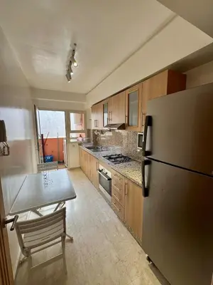 a kitchen with a refrigerator and a table in it at Elegant 2BR, Pool & Gym Access in Marrakech