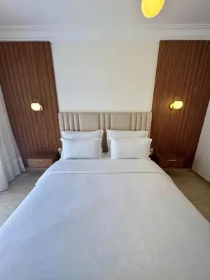 a bedroom with a large white bed with two pillows at Elegant 2BR, Pool & Gym Access in Marrakech