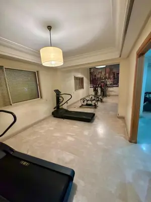 a room with a gym with a treadmill and a room with a treadmill at Elegant 2BR, Pool & Gym Access in Marrakech