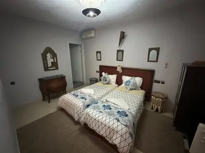 a bedroom with a large bed with blue and white sheets at Cosy private riad 3 rooms in Marrakech