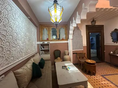 a living room with a couch and a table at Cosy private riad 3 rooms in Marrakech