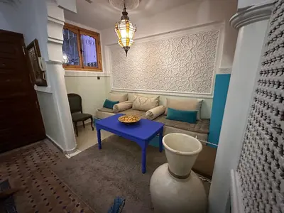 a living room with a blue table and a couch at Cosy private riad 3 rooms in Marrakech