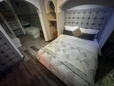 a bedroom with a king sized bed with a headboard at Cosy private riad 3 rooms in Marrakech