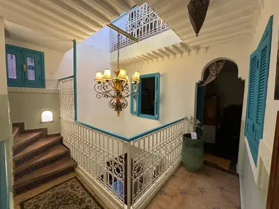 a staircase in a house with a chandelier at Cosy private riad 3 rooms in Marrakech