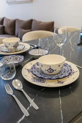 a table with china plates and wine glasses on it at Palmier d'or - Marrakech Centre in Marrakech