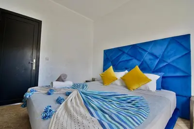 a bedroom with a large bed with a blue headboard at Marrakxi in Marrakech