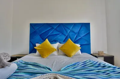 a bed with a blue headboard and yellow pillows at Marrakxi in Marrakech