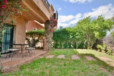 a patio with a table and chairs in a yard at Marrakxi in Marrakech