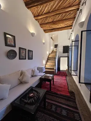 a living room with a couch and a table and stairs at Luxury riad breakfast included in Marrakech