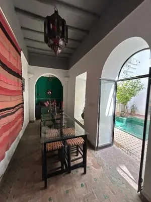 a room with a table and chairs and a pool at Luxury riad breakfast included in Marrakech