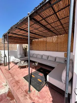 a couch under a pergola on a patio at Luxury riad breakfast included in Marrakech