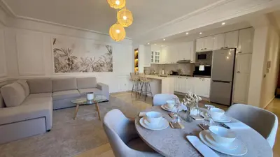 a living room with a dining table and a kitchen at L'Écrin by Louhou Collection - Plein centre in Marrakech