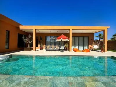 a swimming pool in front of a house at Villa Terracotta Marrakech in Segraga
