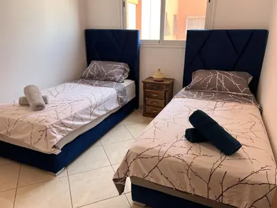 a bedroom with two beds and a window at Khamo Apartment, 15 min Walking to Airport, 15 min by Taxi to Medina in Marrakech