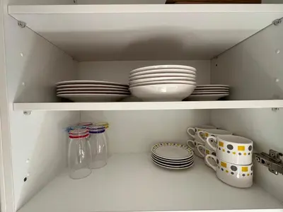 a white cabinet with plates and dishes in it at Khamo Apartment, 15 min Walking to Airport, 15 min by Taxi to Medina in Marrakech