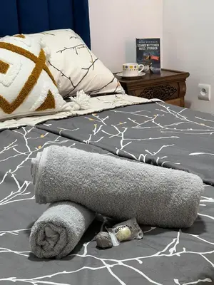 a bed with a pile of towels on the floor at Khamo Apartment, 15 min Walking to Airport, 15 min by Taxi to Medina in Marrakech