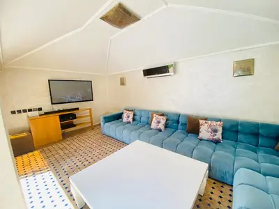 a living room with a blue couch and a tv at Villa Youri in Marrakech