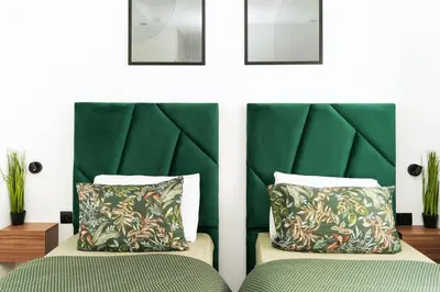a bedroom with a green headboard and two beds at Cosy Appartement de Luxe F3 Menara Garden Hivernage Marrakech avec piscine in Marrakech