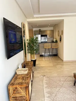 a living room with a television and a kitchen at Luxury studio Gueliz AC Downtown Wi-Fi in Marrakech