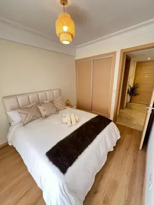 a bedroom with a large white bed with a black blanket at Luxury studio Gueliz AC Downtown Wi-Fi in Marrakech