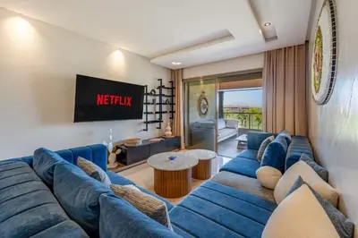 a living room with a blue couch and a tv at Marrakech, mon amour in Marrakech